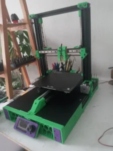 Impresora 3D Ender 3 modificada con componentes Voron, como guías lineales y cabezal Stealthburner, para alto rendimiento. Leyenda: Transformación de Ender 3 a Voron: una mejora sustancial en velocidad y calidad de impresión.